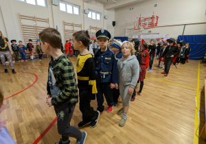 Uczniowie bawią się na balu karnawałowym.