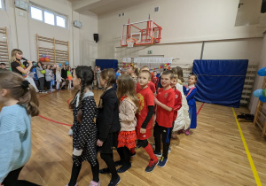 Uczniowie bawią się na balu karnawałowym.