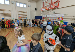 Uczniowie bawią się na balu karnawałowym.