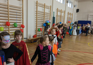 Uczniowie bawią się na balu karnawałowym.
