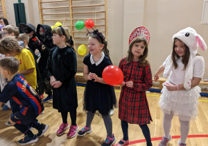 Uczniowie bawią się na balu karnawałowym.