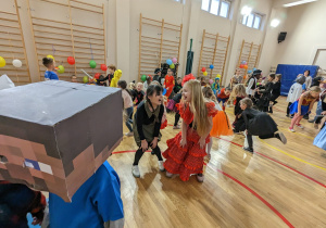 Uczniowie bawią się na balu karnawałowym.