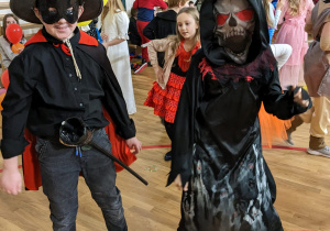 Uczniowie bawią się na balu karnawałowym.