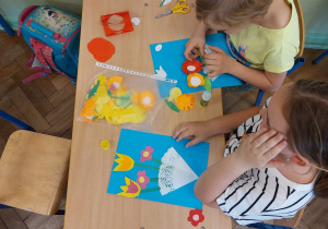 Uczniowie wykonują prace plastyczne z okazji Dnia Mamy.