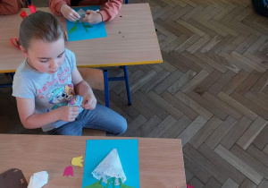 Uczniowie wykonują prace plastyczne z okazji Dnia Mamy.