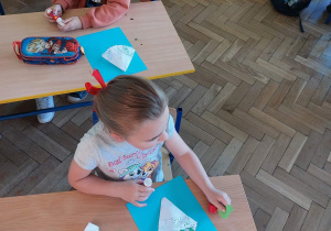 Uczniowie wykonują prace plastyczne z okazji Dnia Mamy.