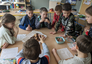 Uczniowie jedzą pączki.