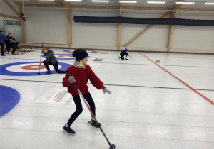 Uczniowie na torze curlingowym.