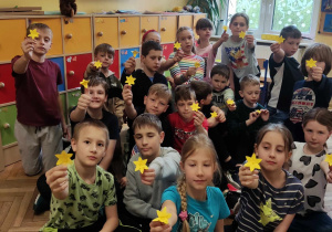Zdjęcie klasy, uczniowie pokazują zrobione żonkile.