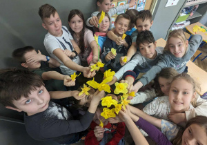 Zdjęcie klasy, uczniowie pokazują zrobione żonkile.