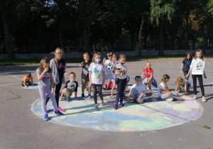 Dzieci rysujące kropki na dziedzińcu szkolnym
