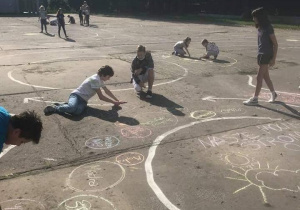 Dzieci rysujące kropki na dziedzińcu szkolnym