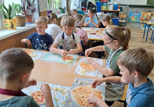 Uśmiechnieci uczniowie szykuja smaczne potrawy