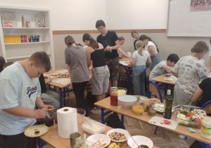 Uśmiechnieci uczniowie szykuja smaczne potrawy