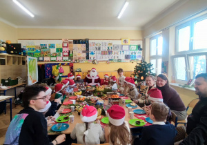 Dzieci z gośćmi przy świątecznym stole