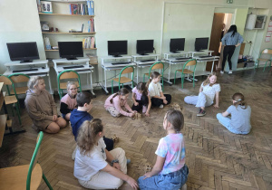 Pies Buba z opiekunem wśród uczniów wykonujących zadania