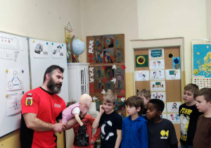 Uczniowie uczą się udzielać pierwszą pomoc niemowlęciu