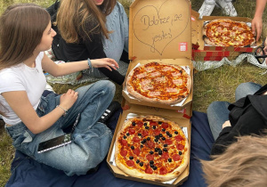 Uczniowie na pikniku z pizzą