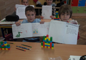 Uczniowie pokazują swoje prace wykonane w czasie lekcji.