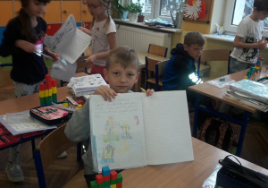 Uczeń pokazuje swoja prace wykonane w czasie lekcji.