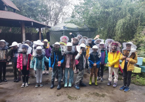 Uczniowie ubrani w kapelusze pszczelarskie.