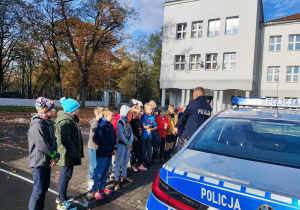 Uczniowie z uwagą słuchają policjanta.