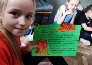 Uczennica prezentuje pracę o tygrysach.